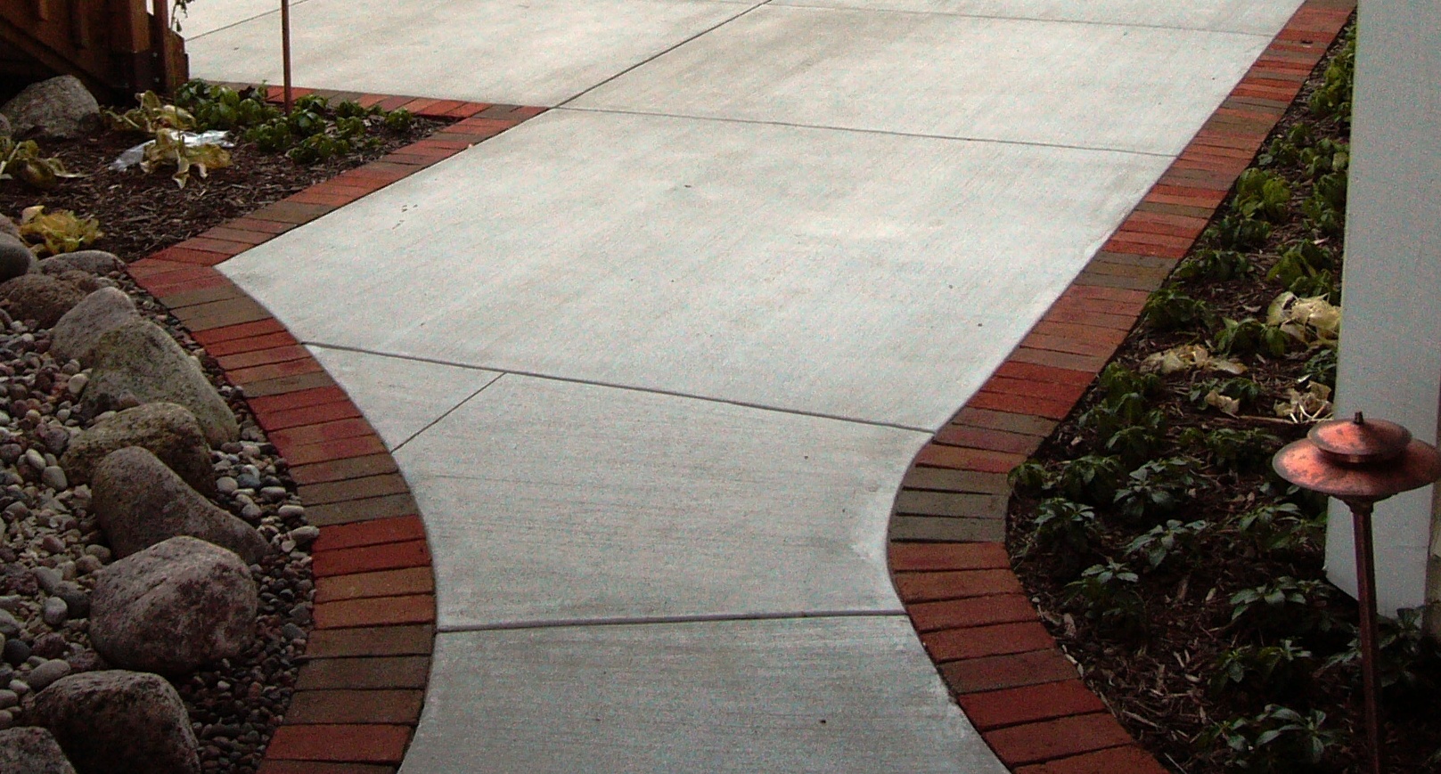 Brick edging along concrete makes a sidewalk more visually appealing.